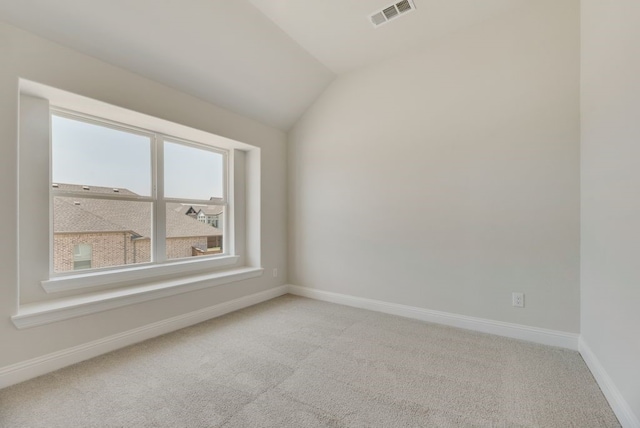 empty room featuring visible vents, baseboards, carpet flooring, and vaulted ceiling