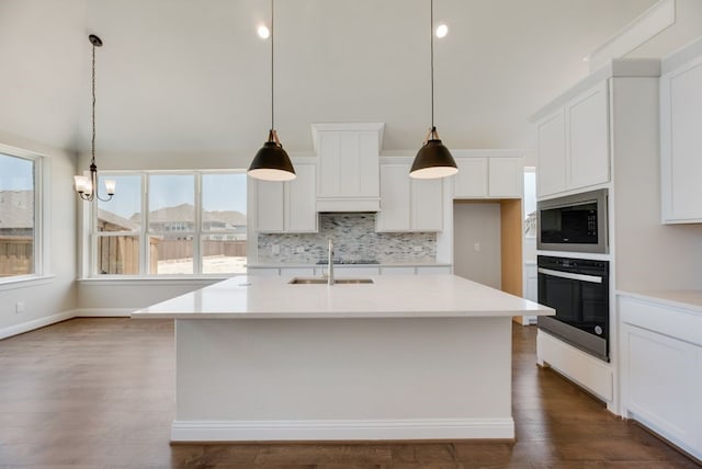 kitchen with tasteful backsplash, oven, built in microwave, white cabinets, and dark wood-style flooring