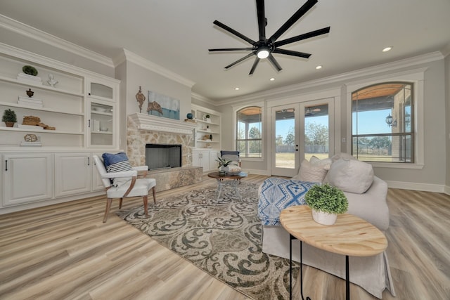 living room with crown molding, a healthy amount of sunlight, and a fireplace