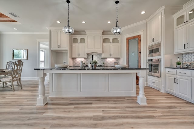 kitchen featuring ornamental molding, pendant lighting, stainless steel appliances, and light hardwood / wood-style floors