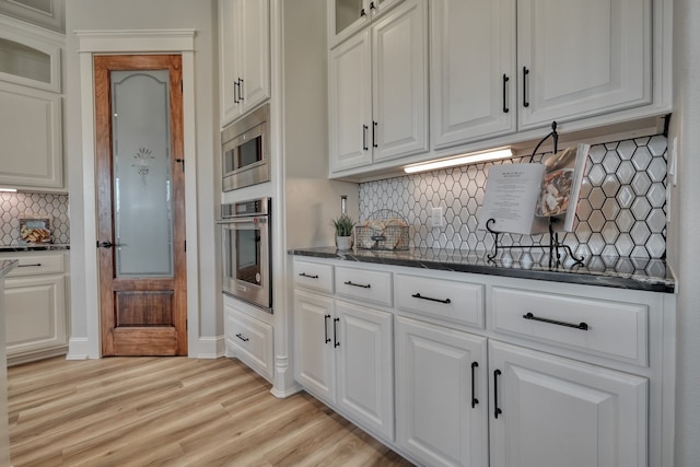 kitchen featuring appliances with stainless steel finishes, backsplash, and white cabinets