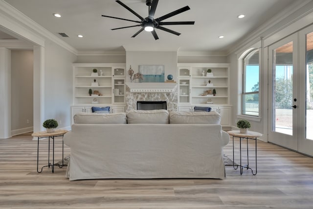 living room with ornamental molding, french doors, light hardwood / wood-style flooring, and ceiling fan