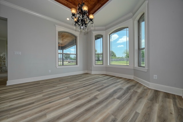 unfurnished room with light hardwood / wood-style floors, an inviting chandelier, and ornamental molding