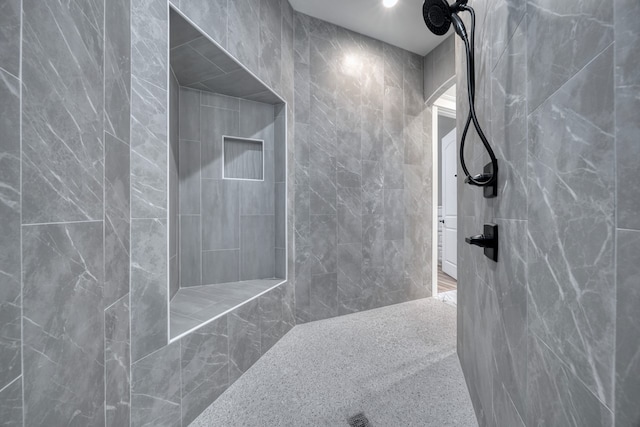 bathroom featuring tile walls and a tile shower