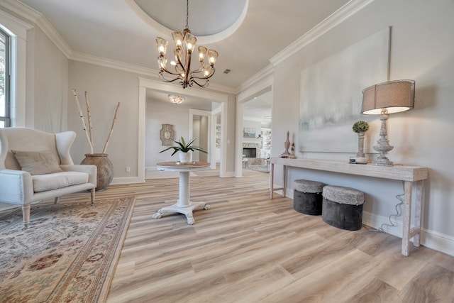 sitting room with crown molding, a notable chandelier, and light hardwood / wood-style floors