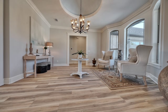 sitting room with an inviting chandelier, crown molding, and light hardwood / wood-style floors