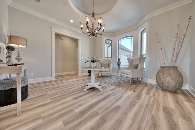 sitting room featuring light hardwood / wood-style floors, crown molding, and an inviting chandelier