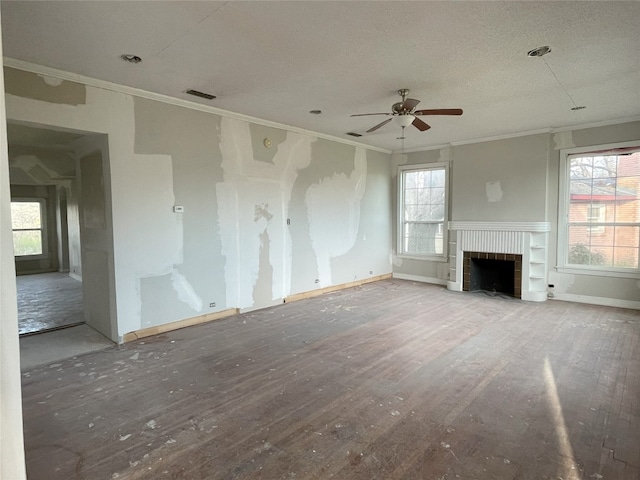 unfurnished living room with a healthy amount of sunlight, ceiling fan, light hardwood / wood-style floors, and a brick fireplace