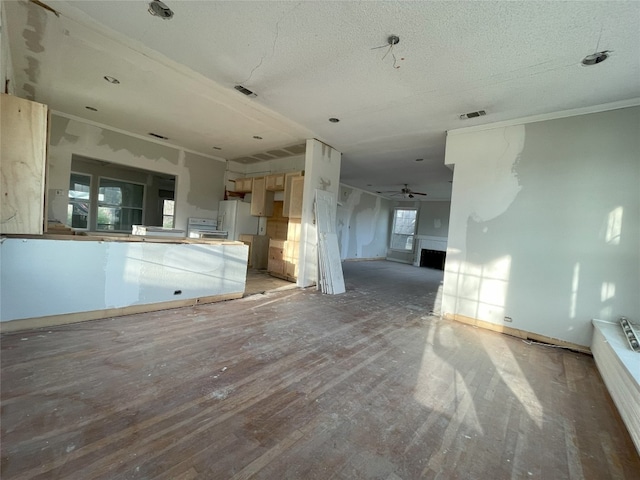 spare room featuring a healthy amount of sunlight, ceiling fan, dark wood-type flooring, and a textured ceiling