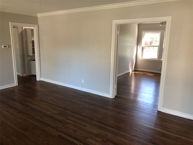 unfurnished room with ornamental molding and dark wood-type flooring