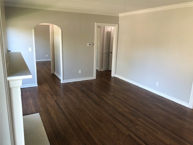 spare room with crown molding and dark wood-type flooring