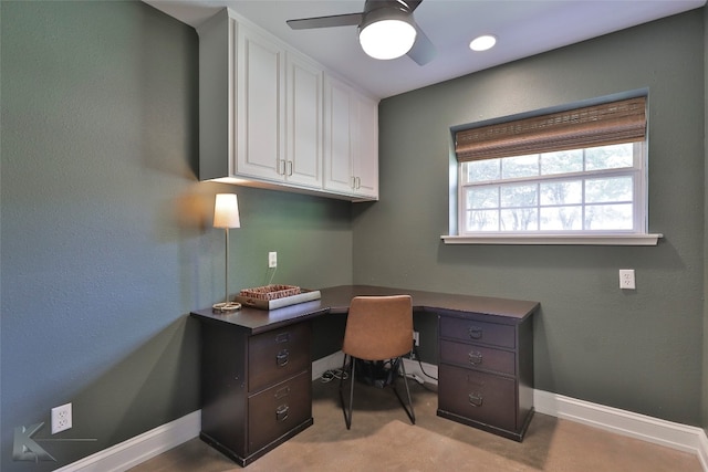 carpeted home office featuring ceiling fan and built in desk