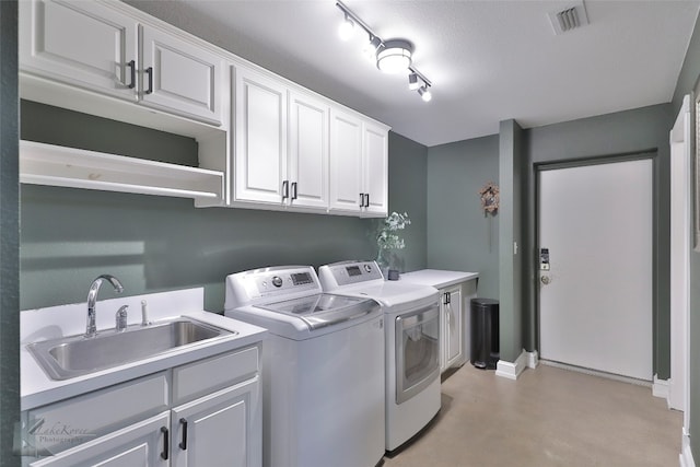 laundry area with washer and dryer, sink, track lighting, cabinets, and a textured ceiling