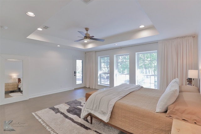 bedroom with a raised ceiling, ceiling fan, and access to exterior