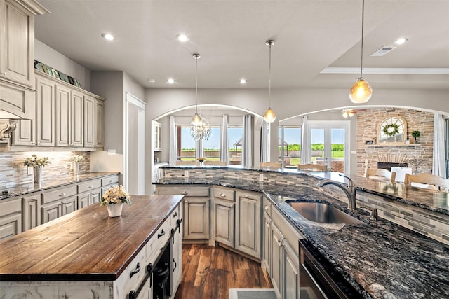 kitchen featuring a kitchen island, sink, dark stone countertops, and decorative backsplash