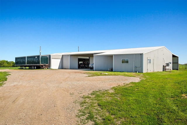 view of front of property featuring a garage, an outdoor structure, and a front yard