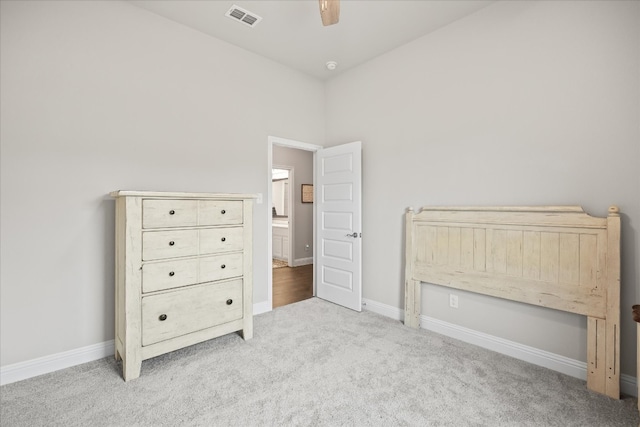 unfurnished bedroom with ceiling fan, light carpet, and a high ceiling