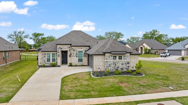 french country home featuring a front lawn and a garage