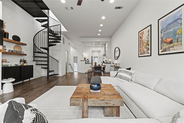 living room with ceiling fan and dark hardwood / wood-style flooring