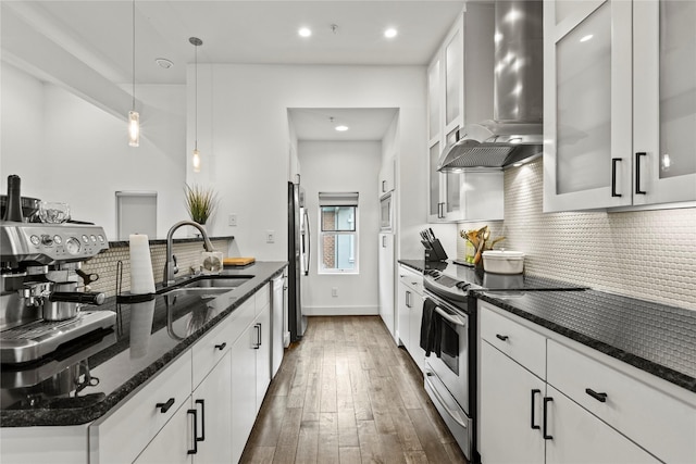 kitchen with sink, wall chimney exhaust hood, dark hardwood / wood-style floors, white cabinets, and appliances with stainless steel finishes