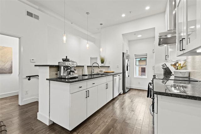 kitchen with dark wood-type flooring, sink, appliances with stainless steel finishes, decorative light fixtures, and white cabinetry