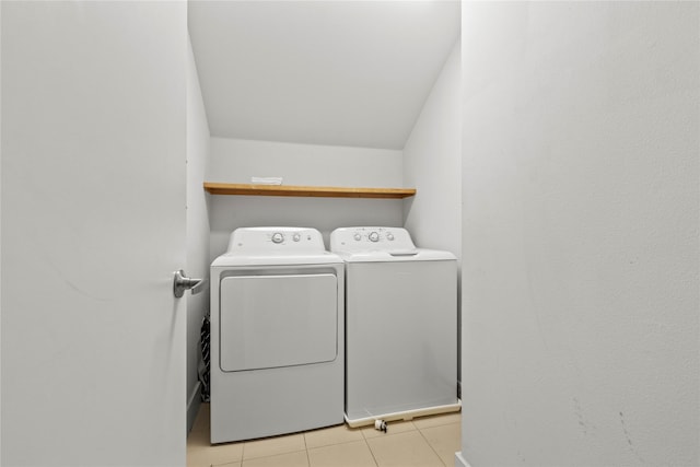 clothes washing area with light tile patterned floors and independent washer and dryer