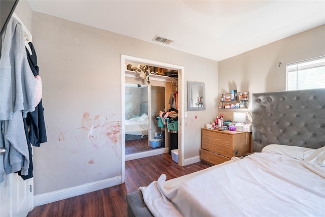 bedroom with dark hardwood / wood-style flooring and a closet