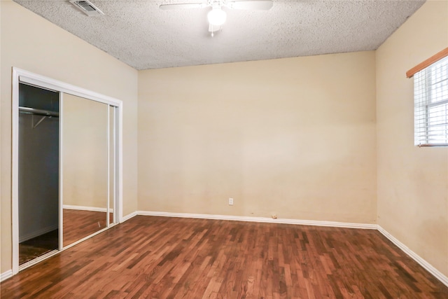 unfurnished bedroom featuring a textured ceiling, a closet, wood-type flooring, and ceiling fan