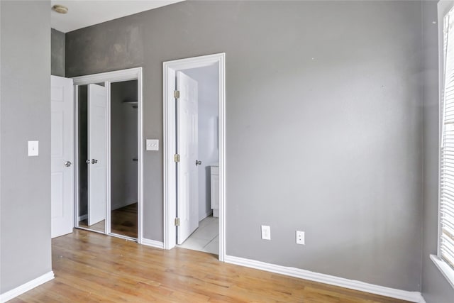 unfurnished bedroom with a closet and light wood-type flooring