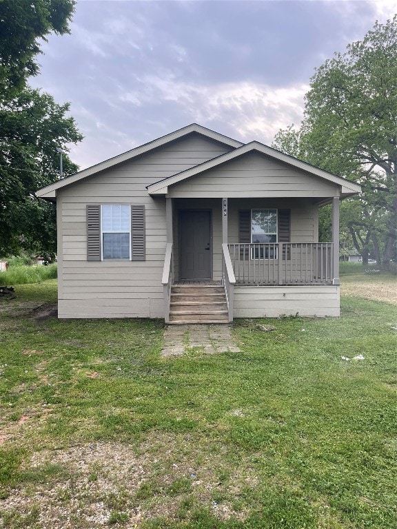 view of front facade with a front yard and covered porch