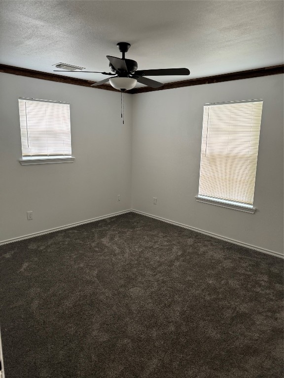 carpeted empty room featuring ceiling fan, crown molding, and a textured ceiling