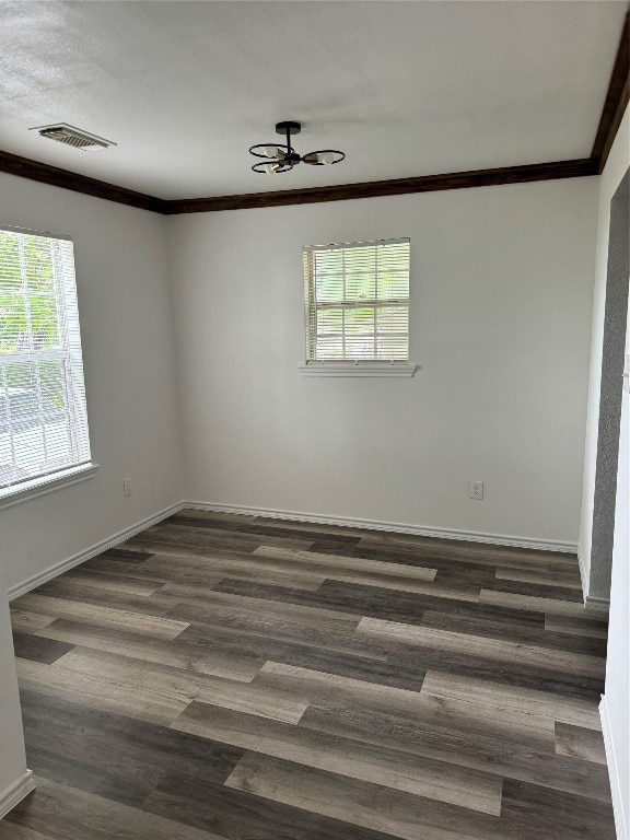 spare room featuring ornamental molding, ceiling fan, and dark wood-type flooring