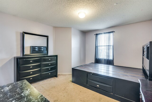 bedroom with light carpet and a textured ceiling