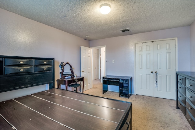 interior space with a closet, a textured ceiling, and light carpet