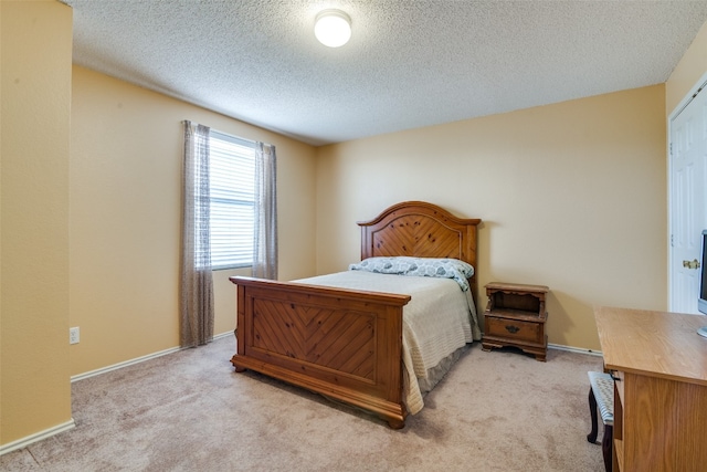 bedroom featuring light colored carpet and a textured ceiling