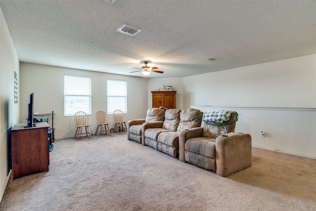 carpeted living room featuring ceiling fan and a textured ceiling