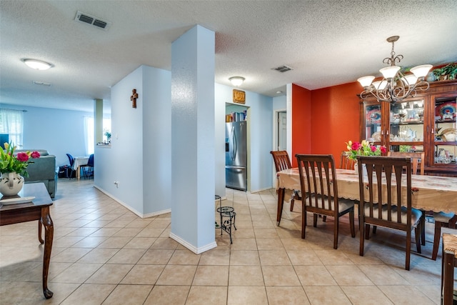 dining room with a textured ceiling and light tile floors