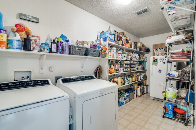 washroom featuring independent washer and dryer, hookup for a washing machine, a textured ceiling, and light tile flooring