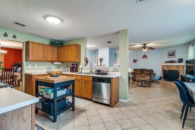 kitchen featuring ceiling fan with notable chandelier, sink, light tile floors, dishwasher, and a textured ceiling