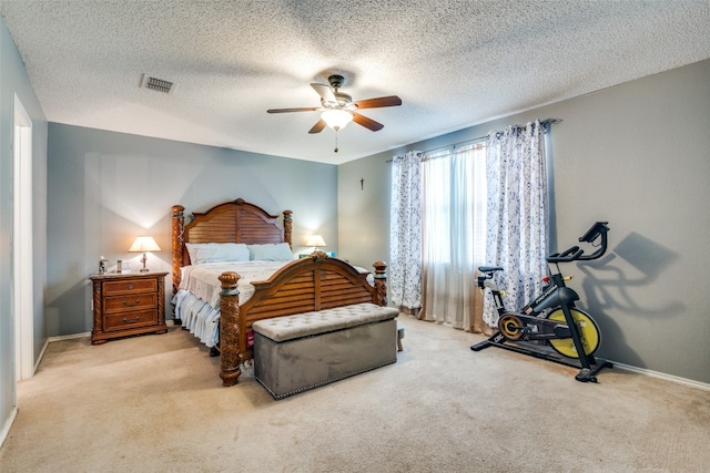 carpeted bedroom with ceiling fan and a textured ceiling