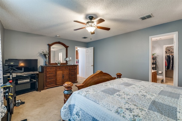 carpeted bedroom with a spacious closet, a closet, ceiling fan, and a textured ceiling