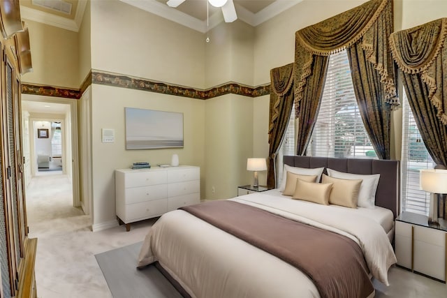 carpeted bedroom with a high ceiling, ceiling fan, and ornamental molding