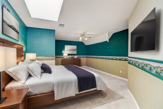 carpeted bedroom with a skylight and ceiling fan