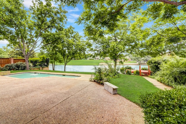 view of pool featuring a lawn, a water view, and a patio