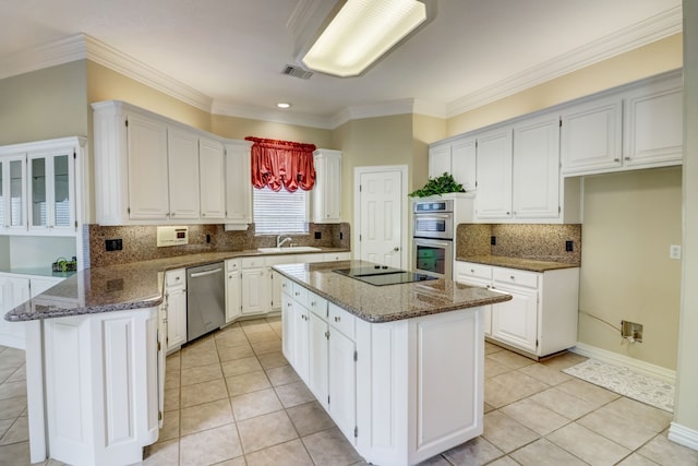 kitchen featuring white cabinets, appliances with stainless steel finishes, a kitchen island, and sink