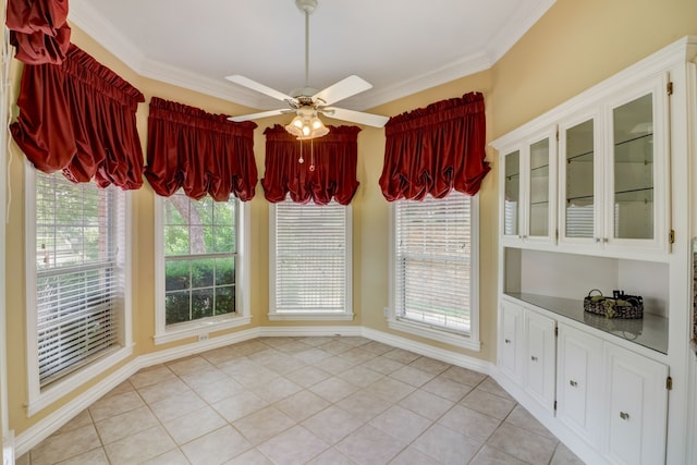 unfurnished dining area with ceiling fan, crown molding, and a wealth of natural light