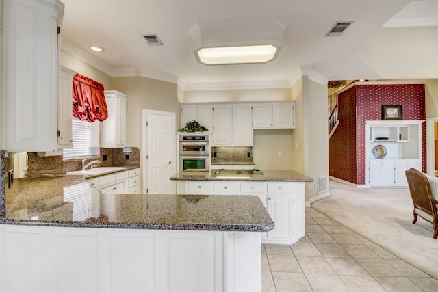 kitchen featuring stainless steel double oven, light colored carpet, crown molding, sink, and white cabinets