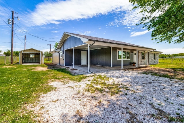 back of property with an outdoor structure and a lawn