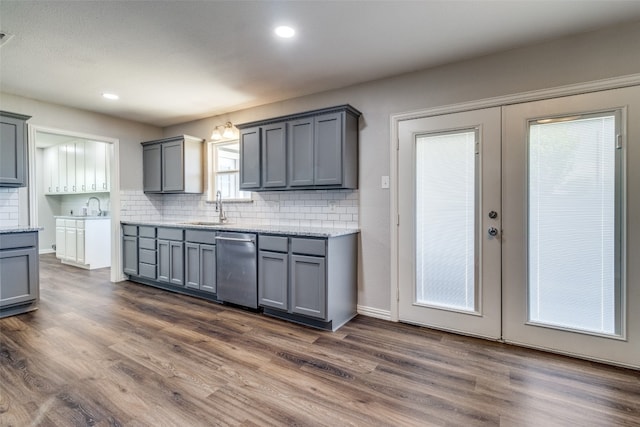 kitchen with dark hardwood / wood-style floors, tasteful backsplash, dishwasher, and gray cabinetry