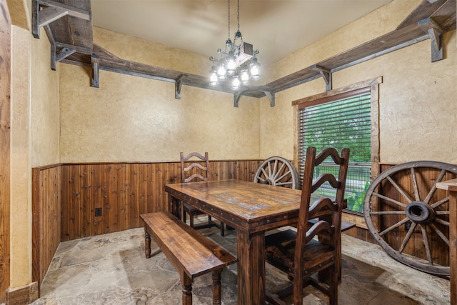 dining room featuring wooden walls and an inviting chandelier